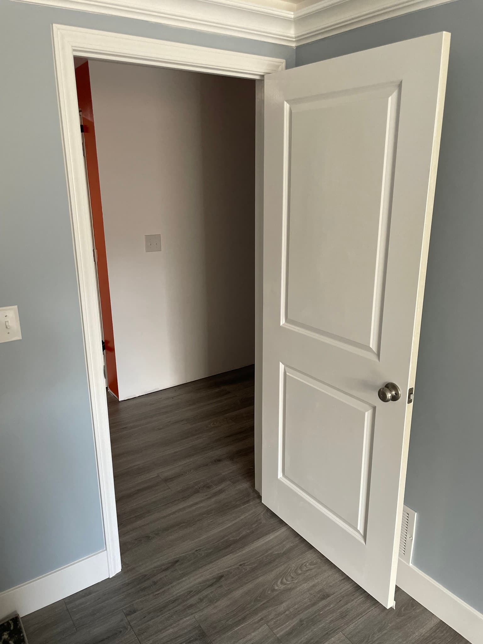 White interior door leading into room with dark flooring
