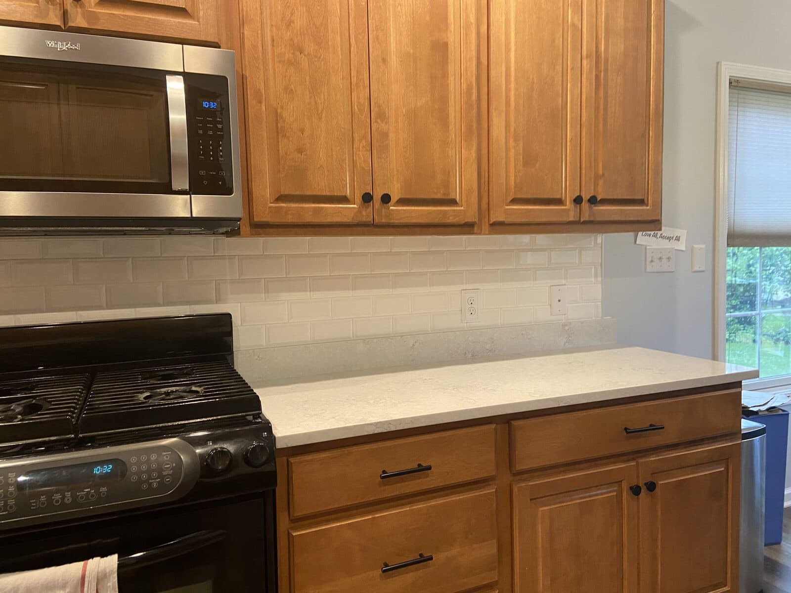 Kitchen range and microwave with white subway tile backsplash
