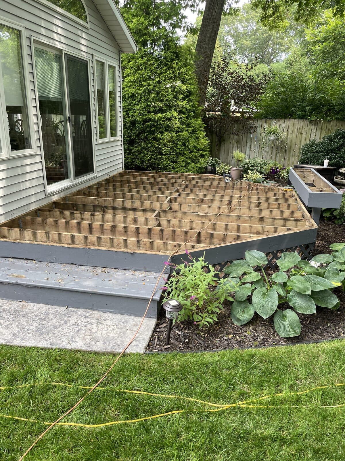 Composite deck framing in progress next to paver landing